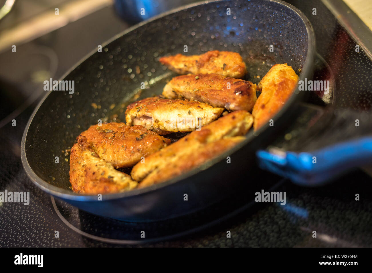 spiced chicken breast fillets in the pan Stock Photo