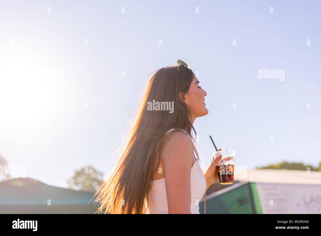Girl enjoying the moment at a festival with a drink on a sunny day in munich Stock Photo