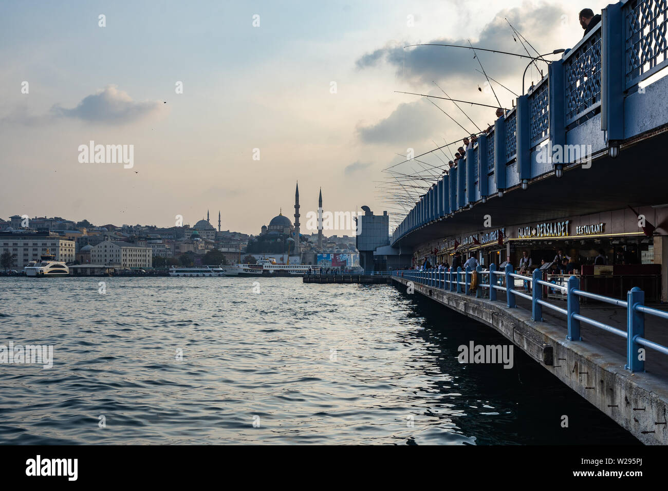 Istanbul Galata Bridge has two levels: on the upper level, fishermen fishing in Bosporus, on the lower level there are many café and restaurants Stock Photo