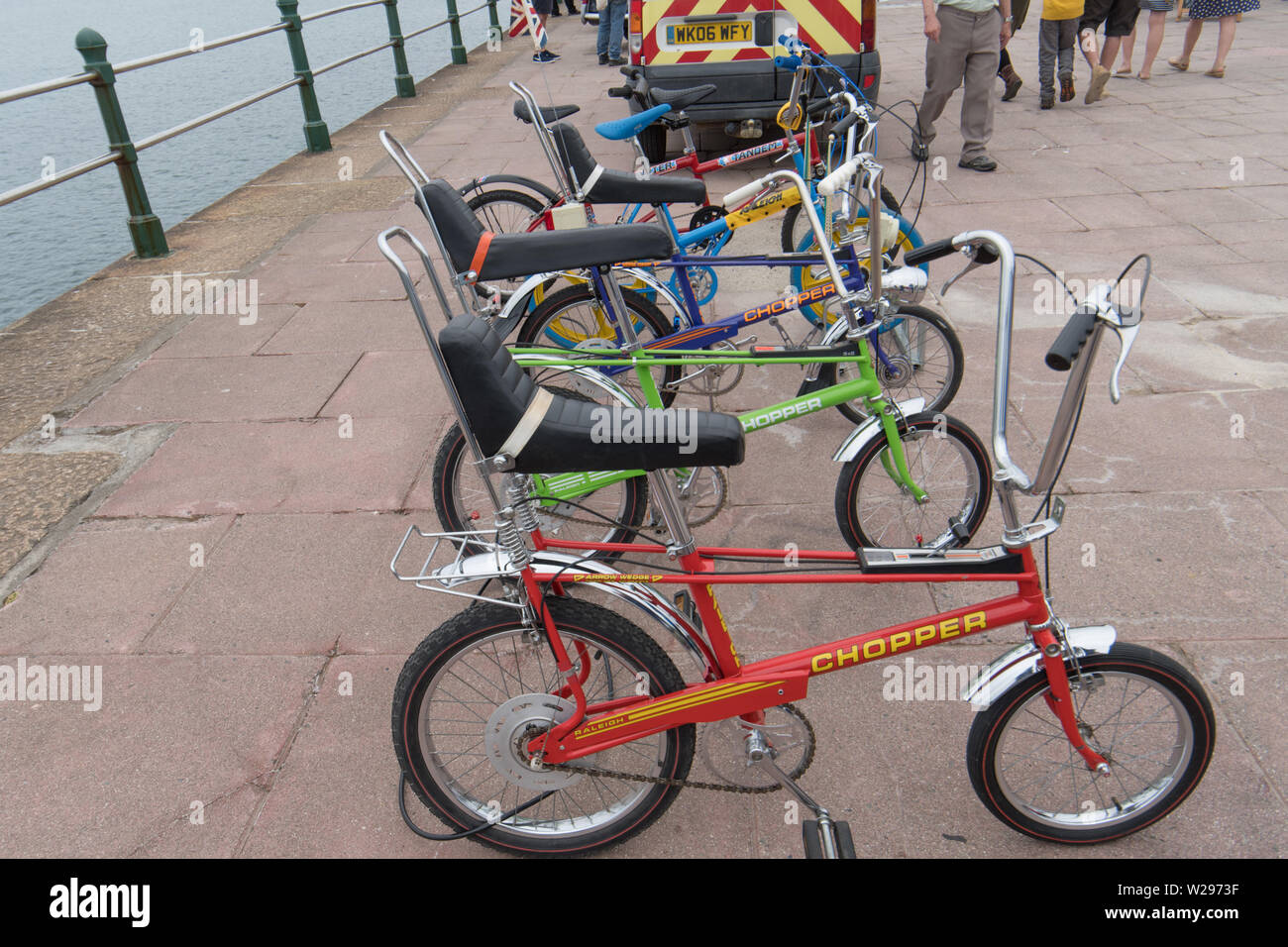 Raleigh Chopper bikes on exhibition outside on seafront at Penzance, peoples upper bodies cropped out Stock Photo