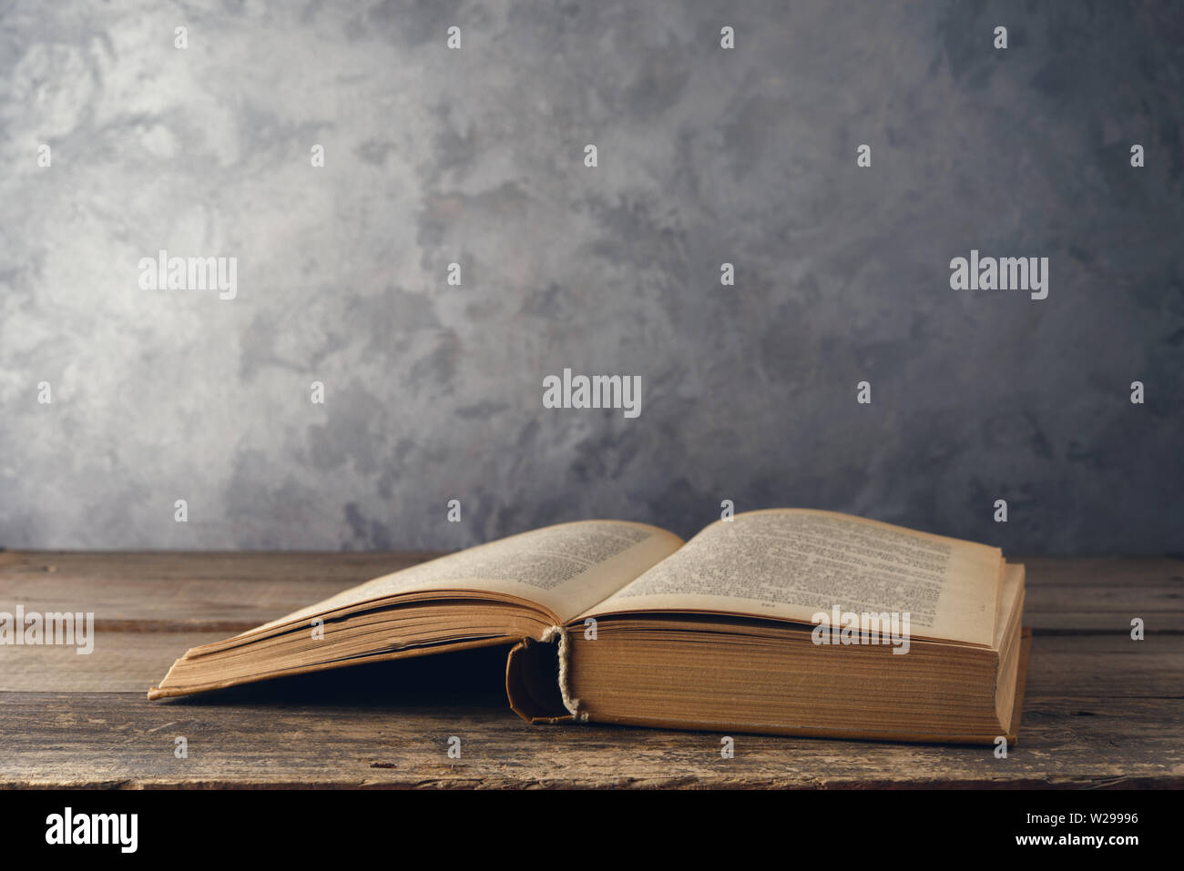 Open book on the table against the wall Stock Photo