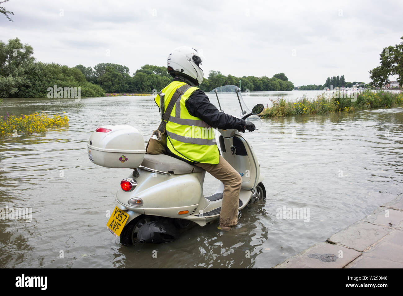 A rider on a scooter braving the high water and flooding on the River