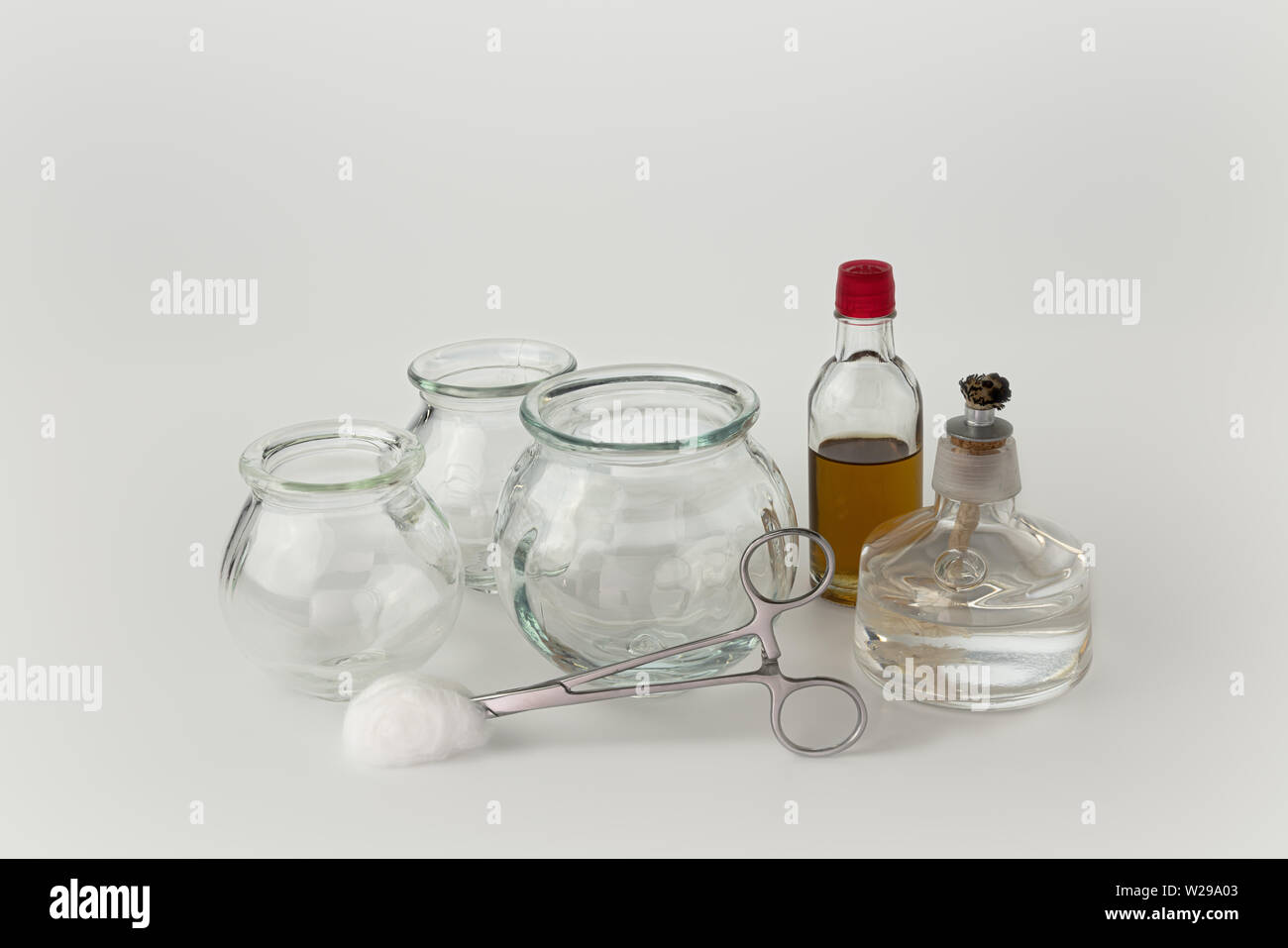 A group of glass fire cups displayed with massage oil,spirit burner and