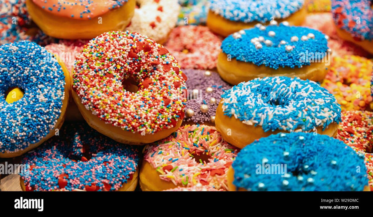 Assorted donuts, bakery display. Colorful donuts assortment background. Close up view Stock Photo