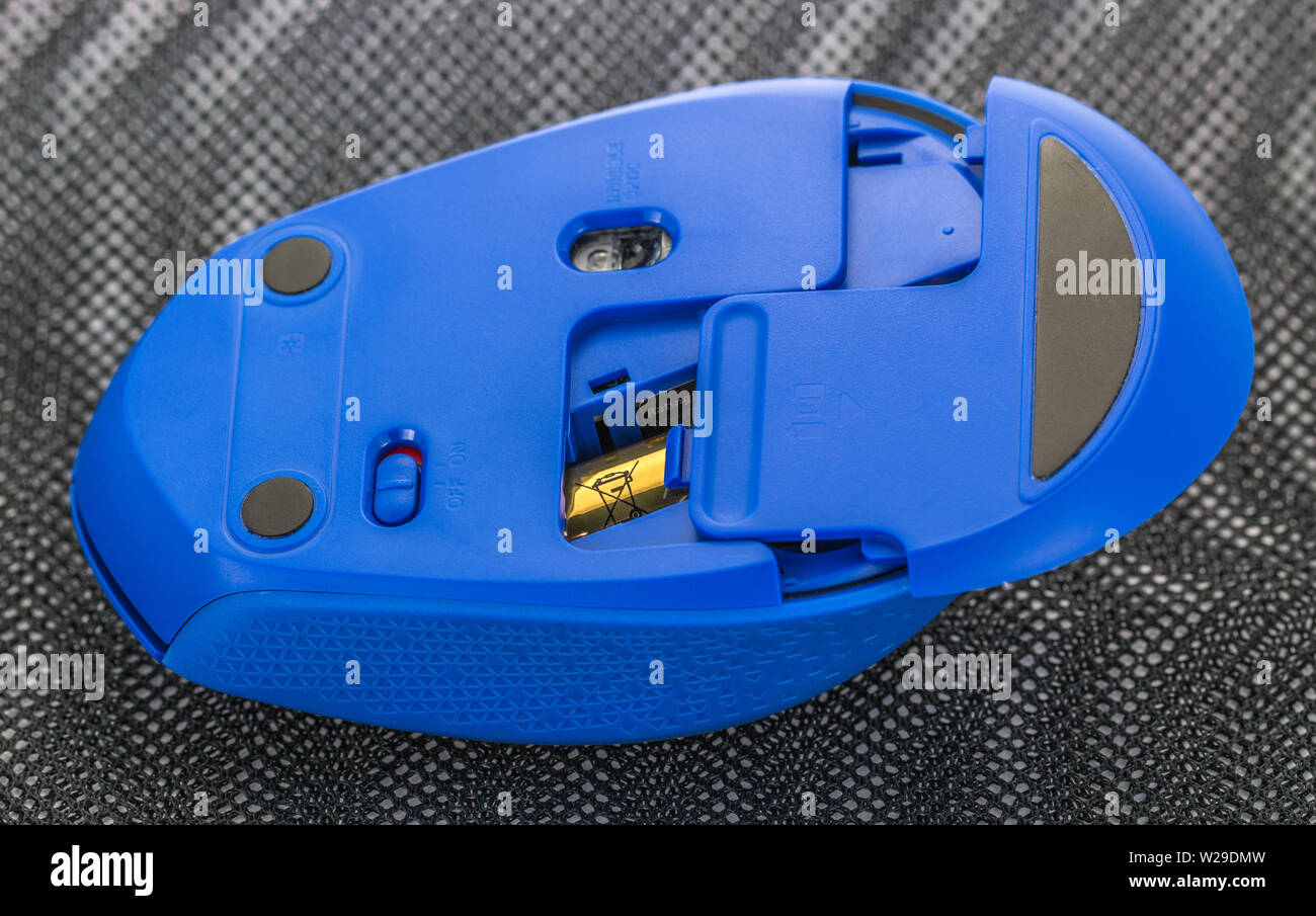 Changing batteries on a wireless computer mouse Stock Photo Alamy