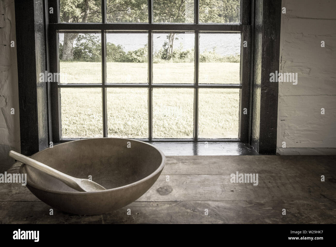 Country Kitchen Interior. Rustic style kitchen with wooden spoon and bowl on antique wooden table Stock Photo