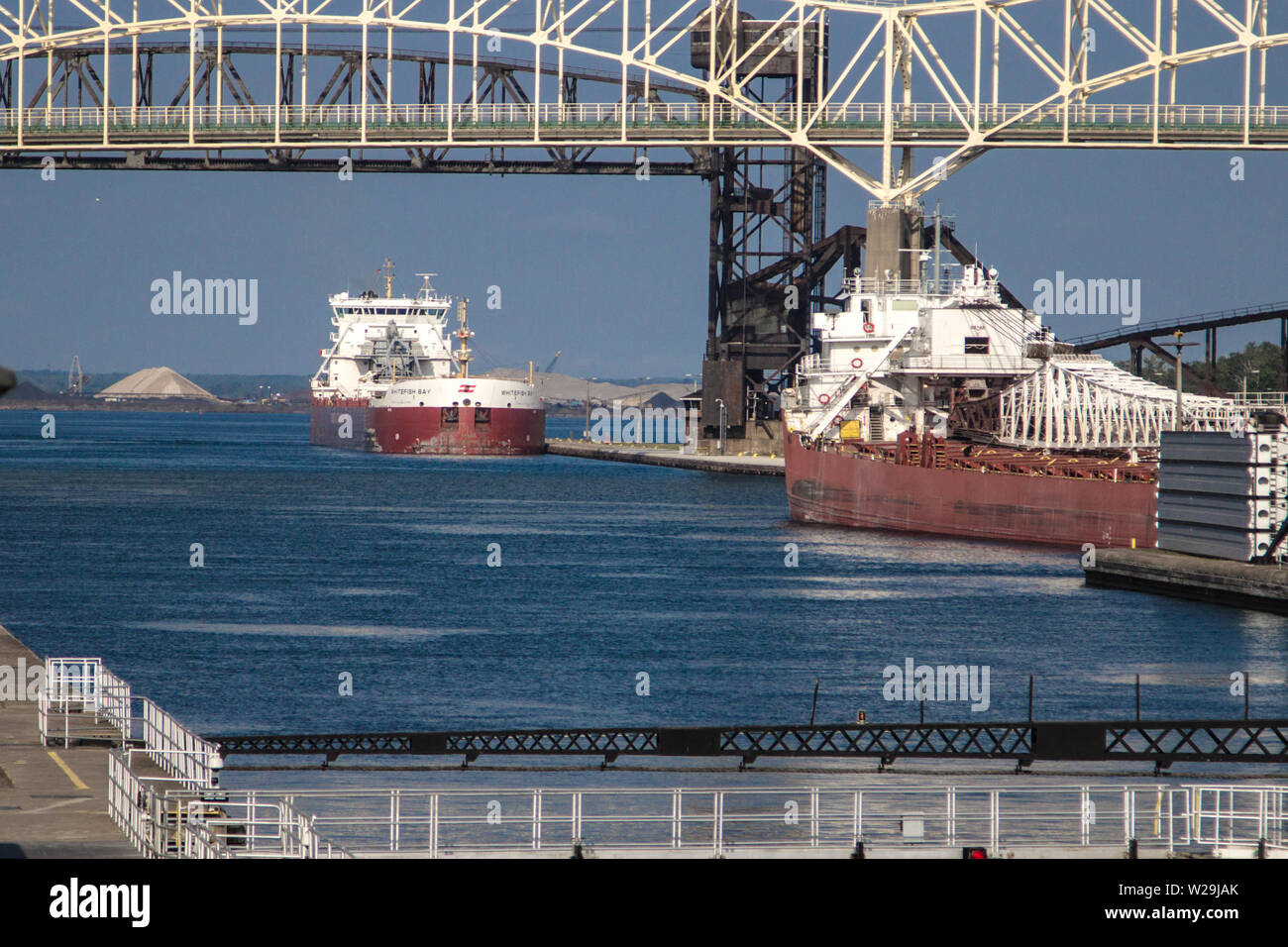 Sault Ste Marie, Michigan, USA - Large Great Lakes freighters line up at the Soo Locks under the International Bridge. Stock Photo
