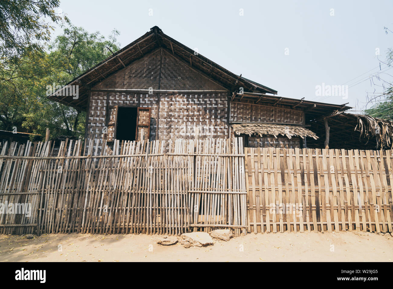 Bagan, Myanmar - March 2019: rustic bamboo hut and it's backyard in a rural village of Bagan. Stock Photo