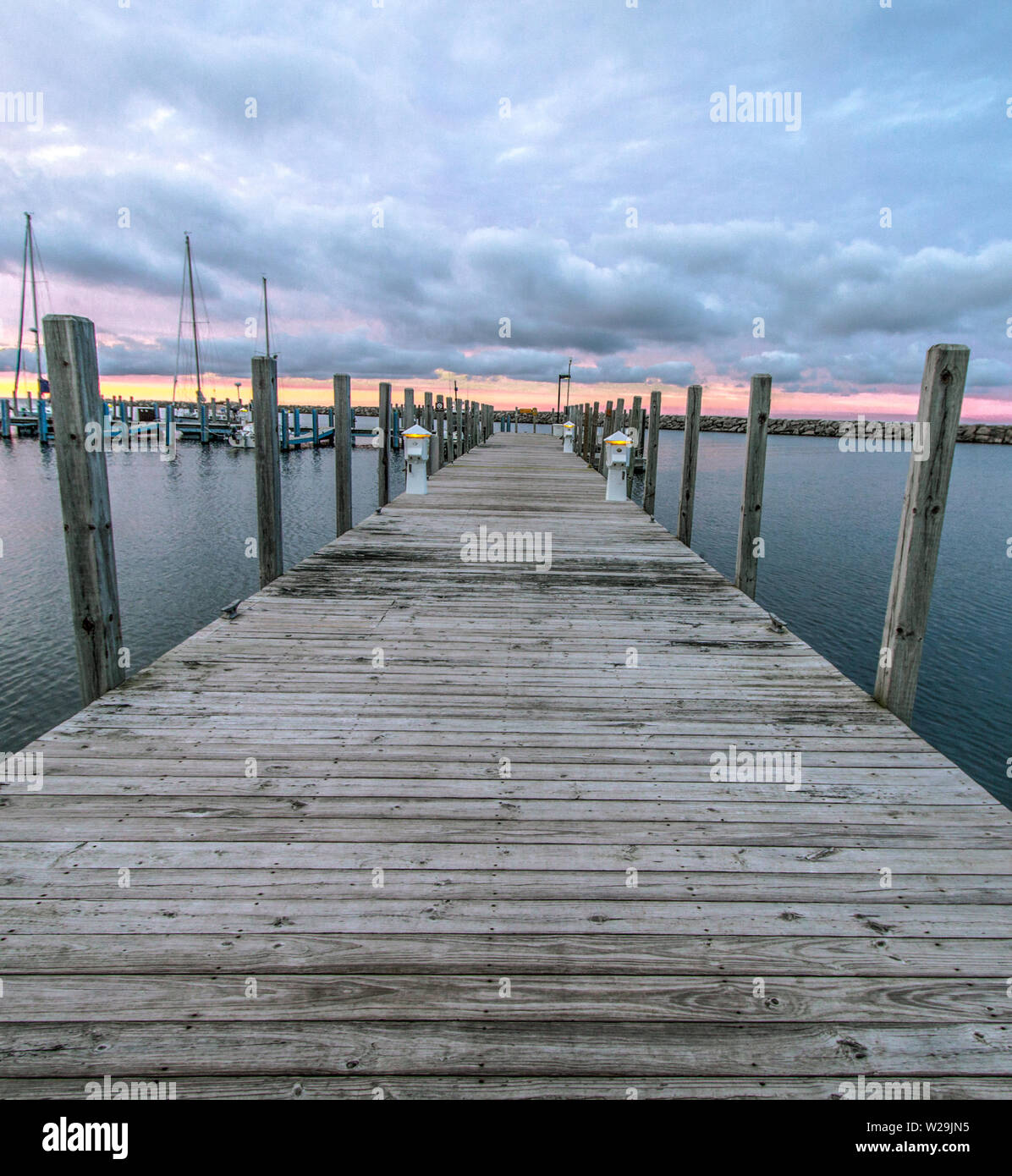 Wooden dock and marina with boats in vertical orientation on the coast of Lake Huron in Michigan. Stock Photo