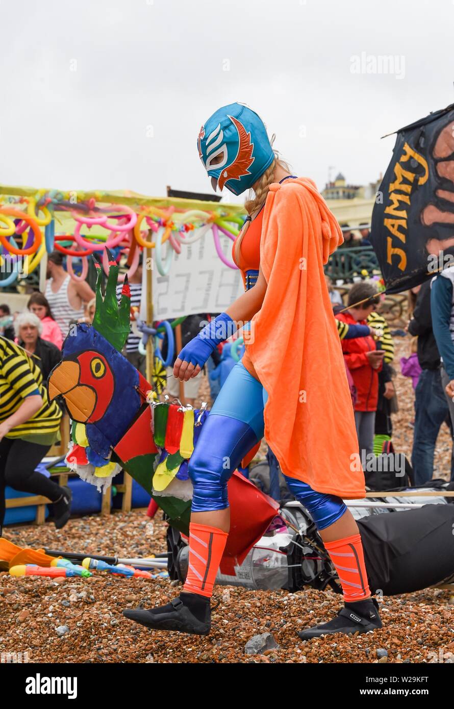 Brighton UK 7th July 2019 -  Competitors dressed in Mexican wrestling outfits  prepare for this years Paddle Round the Pier beach festival in Brighton . The annual Paddle Round the Pier is now the largest free beach festival in Europe raising money for various charities including Surfers Against Sewage  . Credit : Simon Dack / Alamy Live News Stock Photo