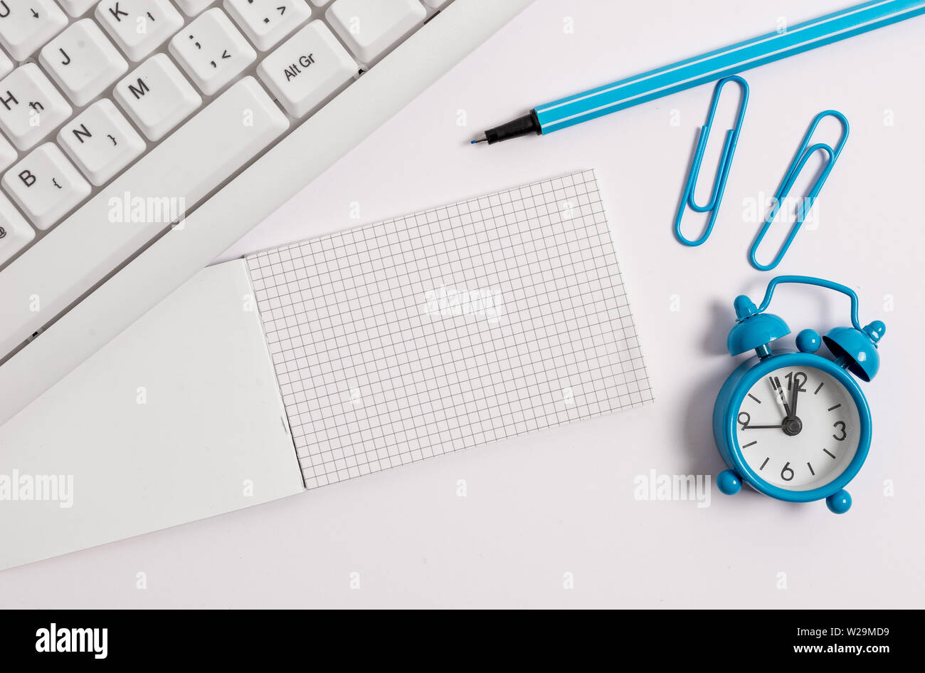 White pc keyboard with empty note paper and paper clips above white background Stock Photo Alamy