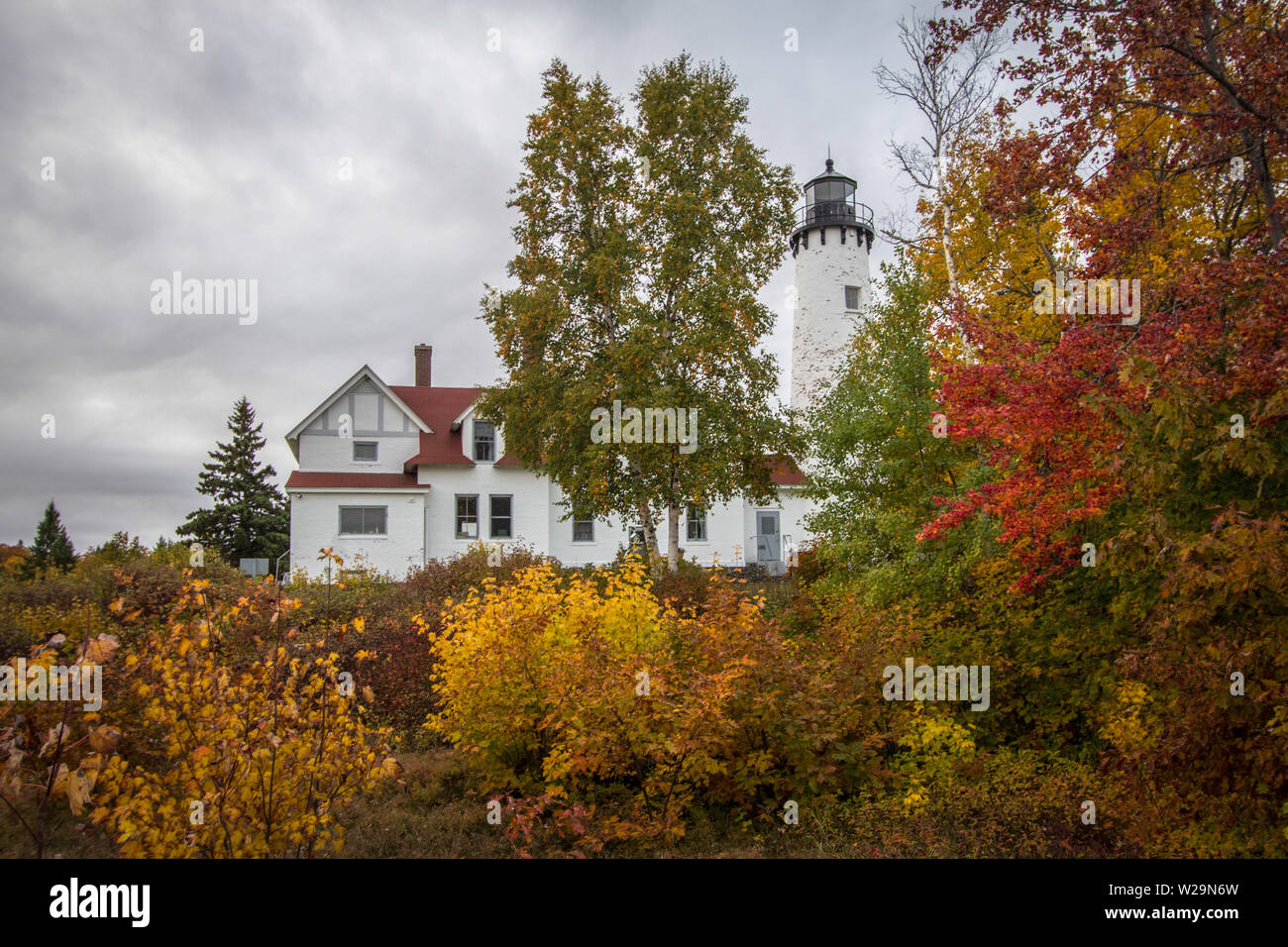 Michigan Autumn Lighthouse. The Point Iroquois Lighthouse with fall foliage on the coast of Lake Superior. Hiawatha National Forest. Brimley, Michigan. Stock Photo