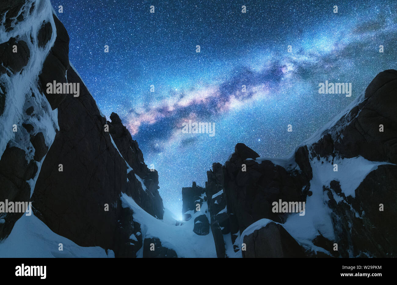 Milky Way and snowy mountains at night. Space Stock Photo