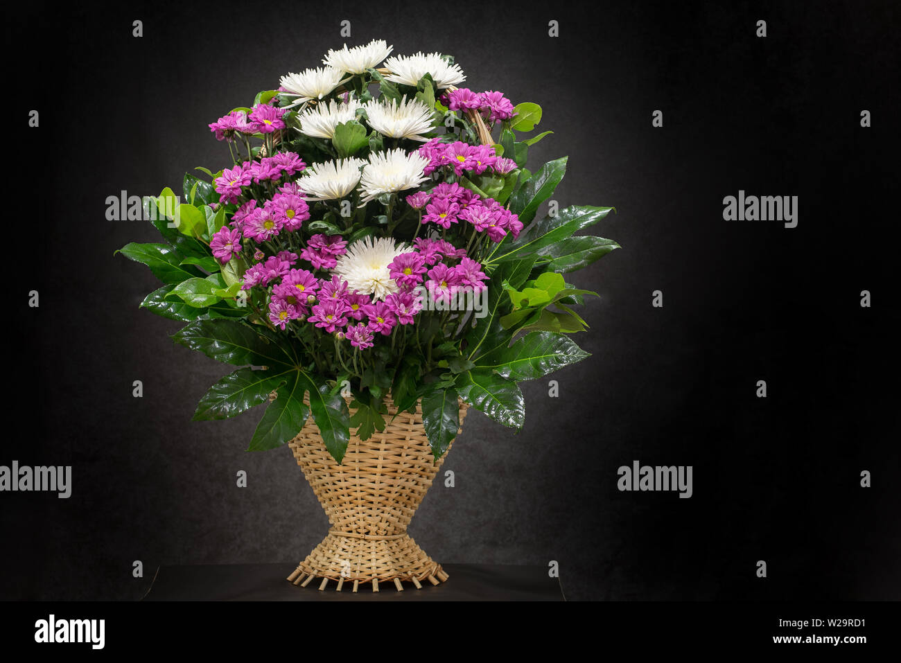 Ritual funeral basket with flowers on a black background.The flower