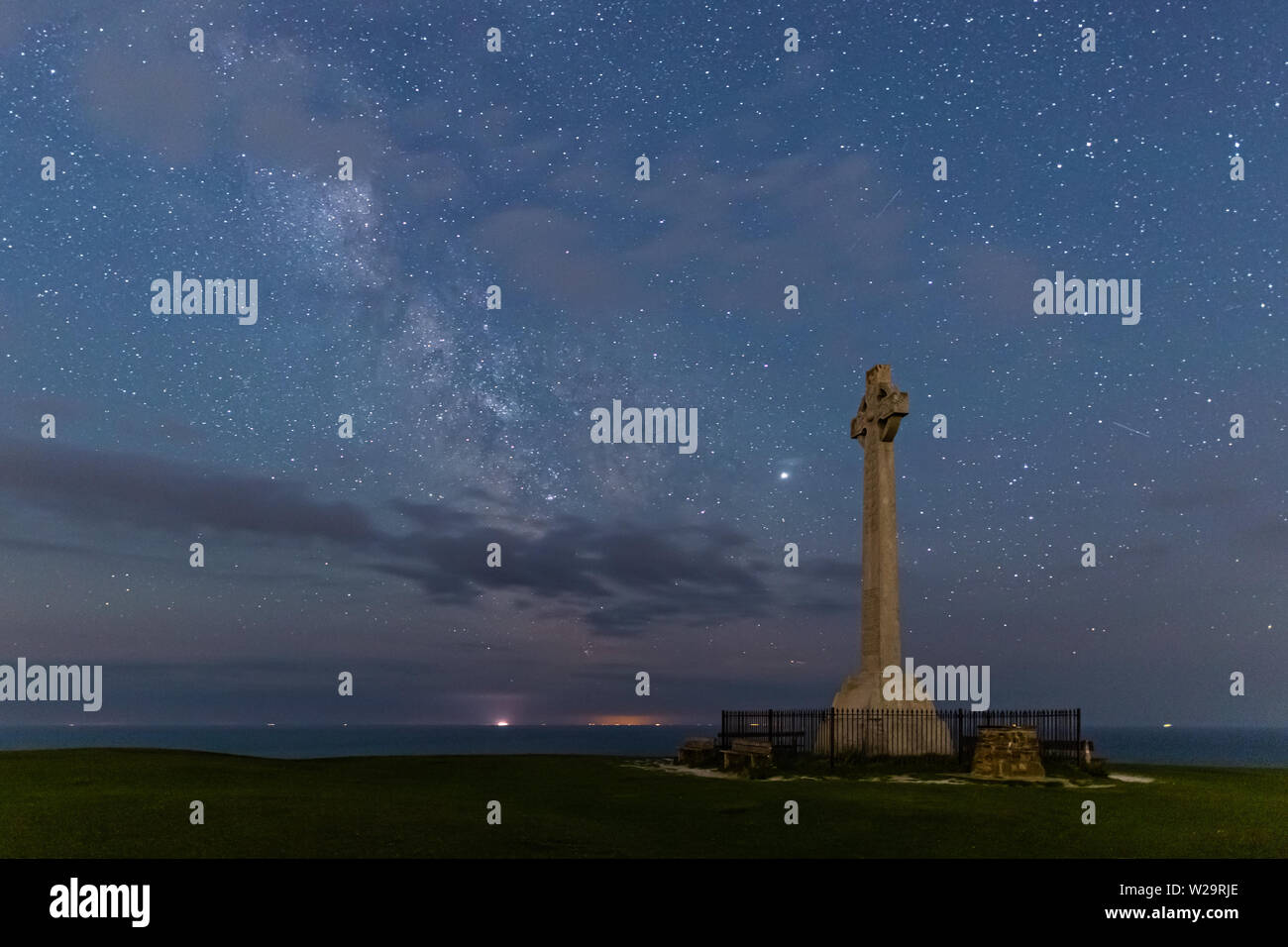 The Milky Way rising by the Tennyson Down monument near Totland on the Isle of Wight Stock Photo