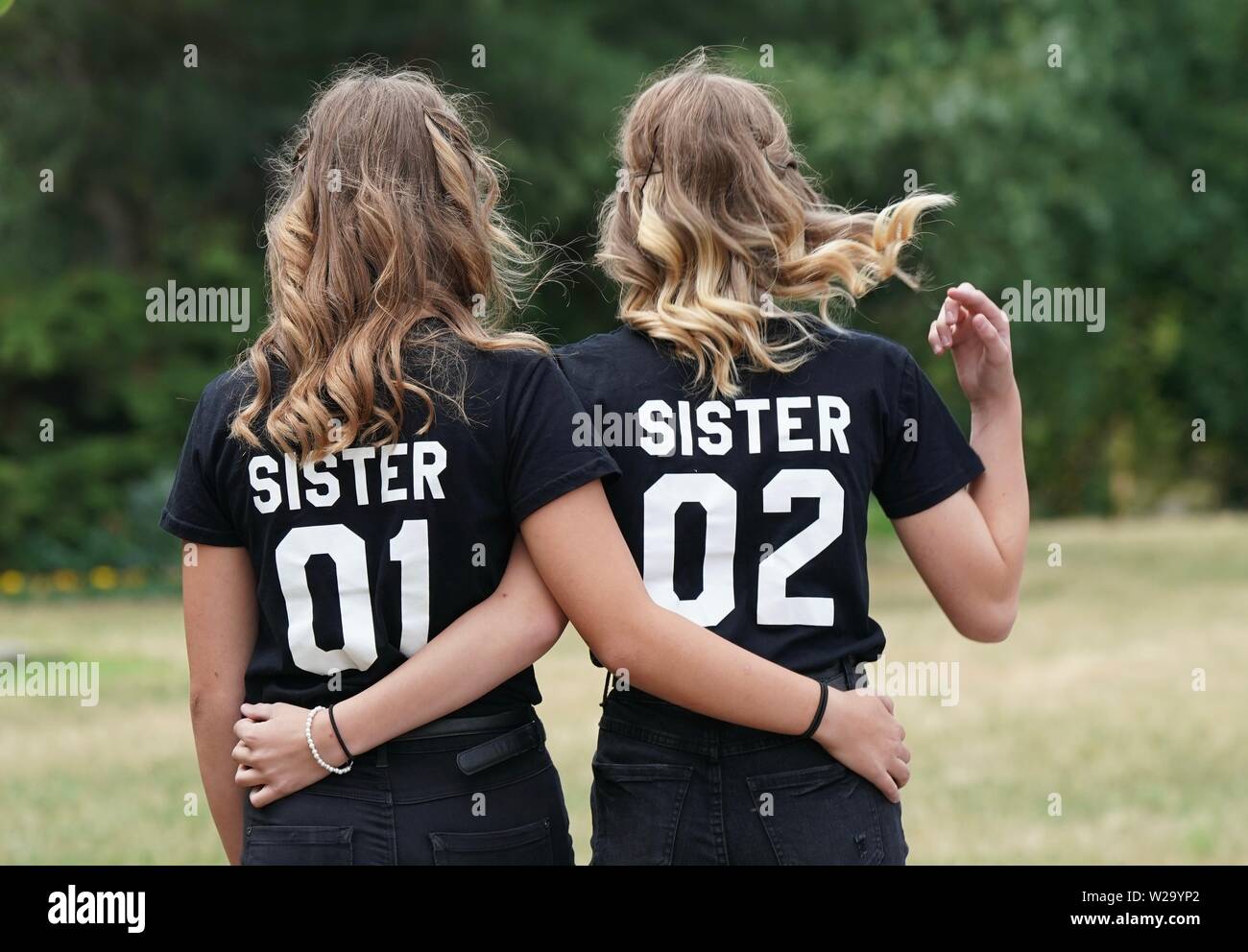 Lutherstadt Wittenberg, Germany. 07th July, 2019. A pair of twin siblings  walk arm in arm with a T-shirt with the inscription "Sister 01" and "Sister  02" on the edge of the 14th