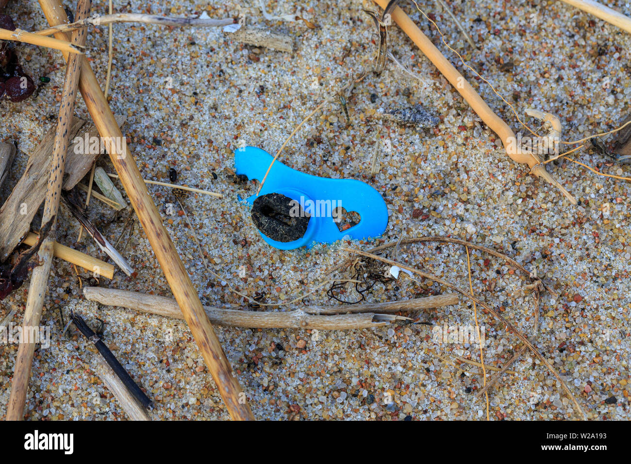 Environmental pollution - remain of a pacifier lying on a beach Stock Photo