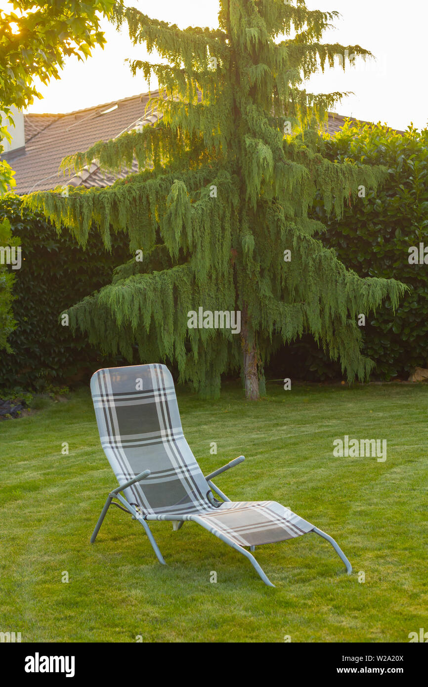 lounger chair on lawn in garden Stock Photo