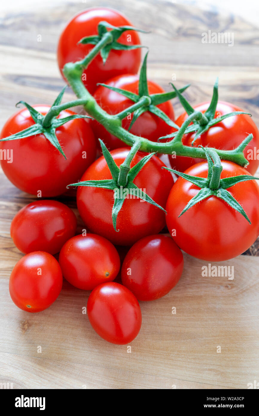 Vive and cherry tomatoes on wooden surface Stock Photo
