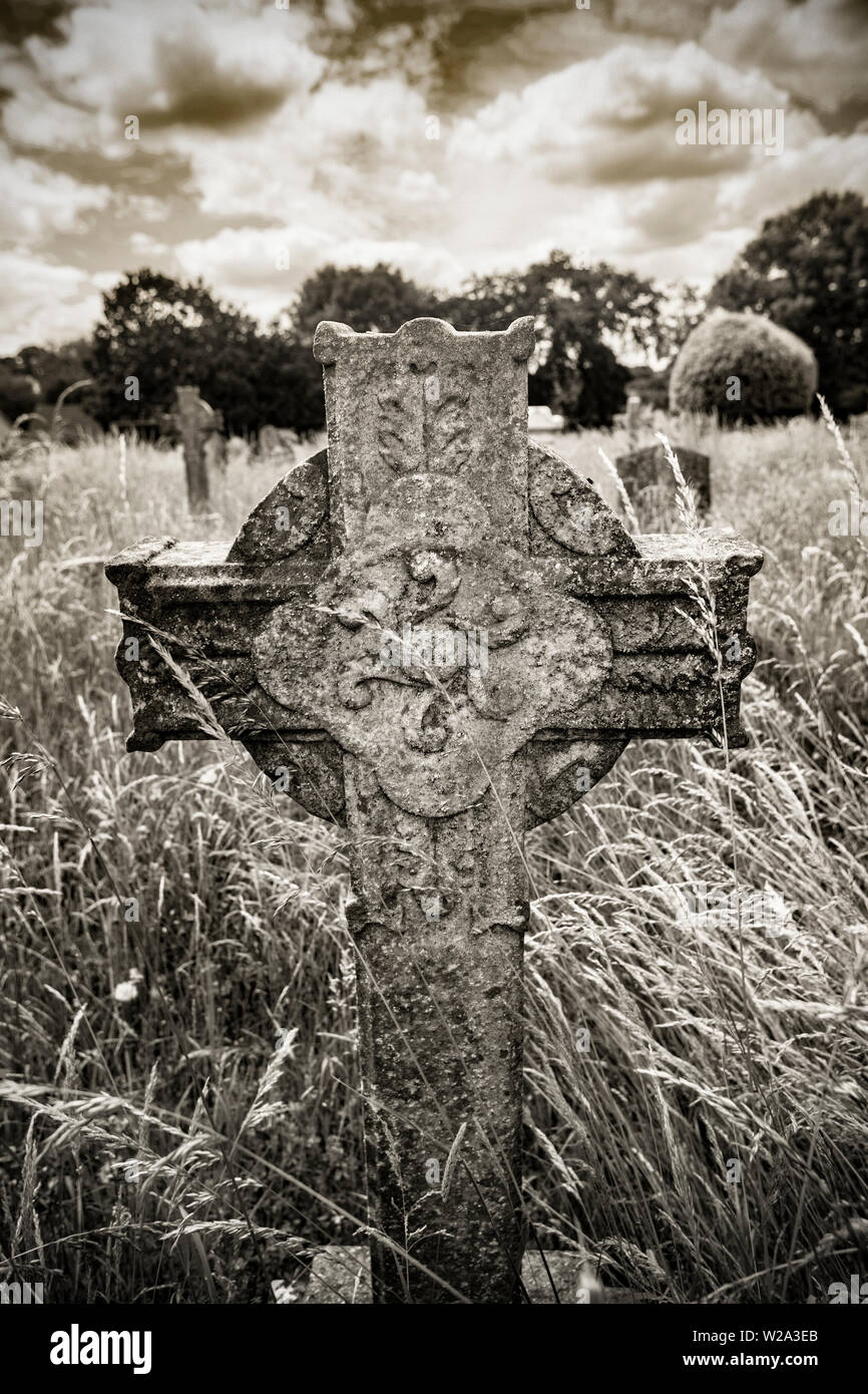 A stone cross gravestone in Gillingham Cemetery Dorset. Black and white sepia digital photograph. Dorset England UK GB Stock Photo
