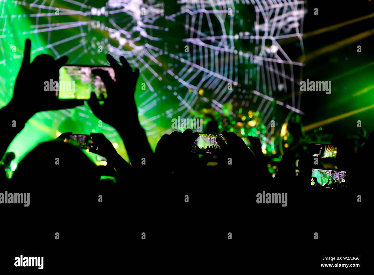 Collecting digital memory is loosing capability of being present, silhouette of people shooting the pop rock concert with mobile phones Stock Photo