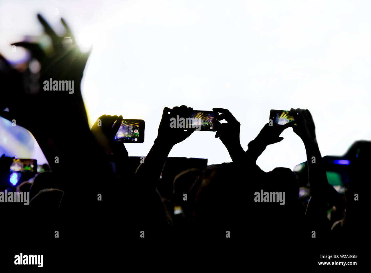 Collecting digital memory is loosing capability of being present, silhouette of people shooting the concert with mobile phones Stock Photo