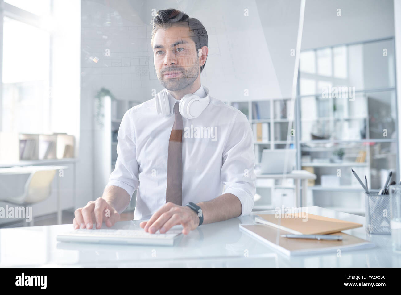 Young confident designer looking at computer screen Stock Photo