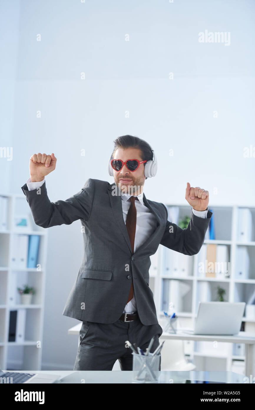 Positive man listening music with headphones, dancing on dark neon  background. Stylish student guy enjoying life, active energy, inspired  dance concept - a Royalty Free Stock Photo from Photocase