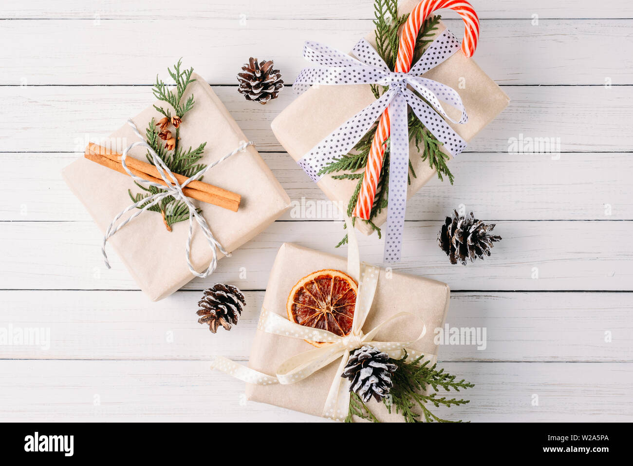 Gift Box With Pine Cones And Cinnamon Sticks On White Background