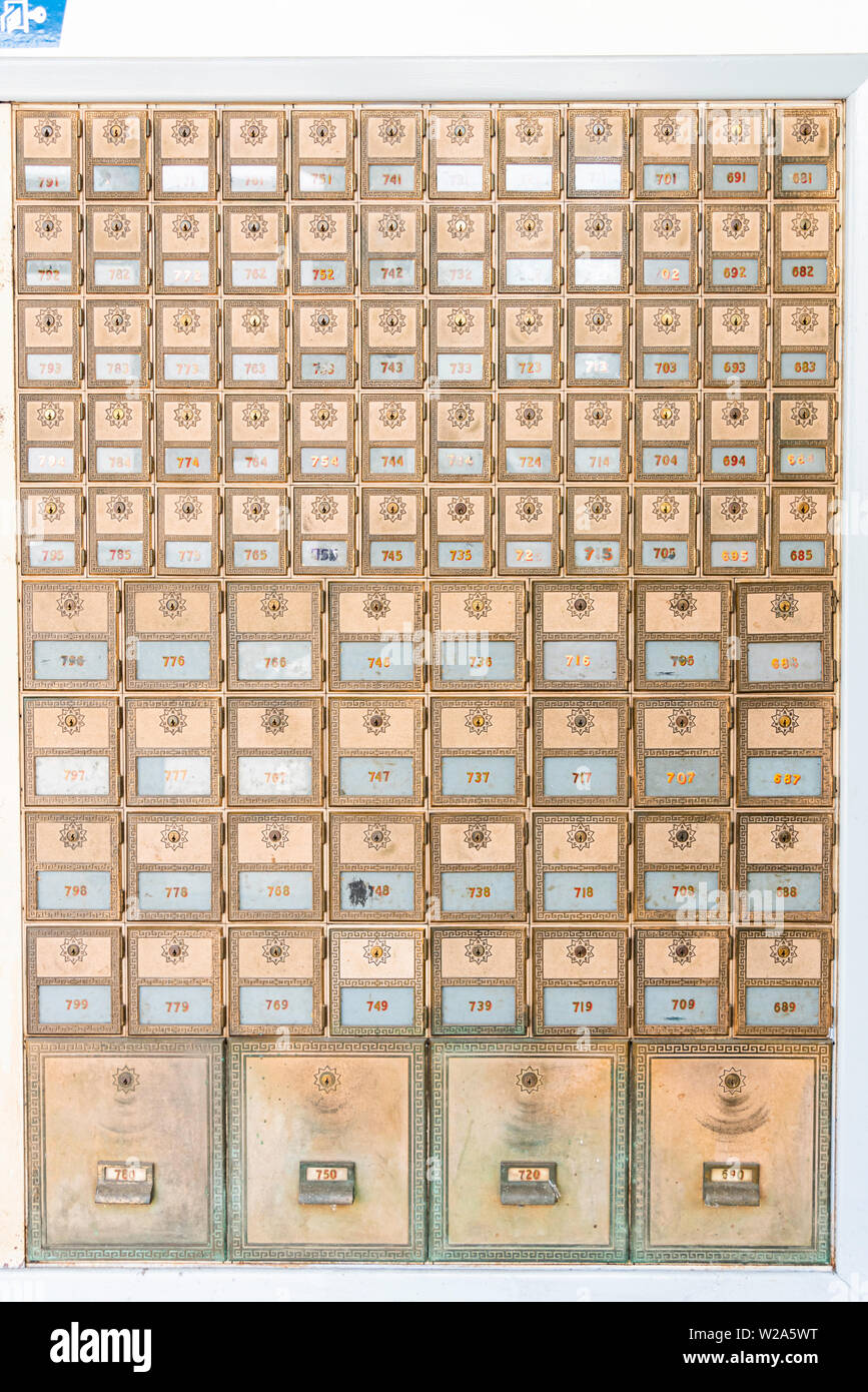 Rows of midcentury modern design post office mailboxes in brass metal