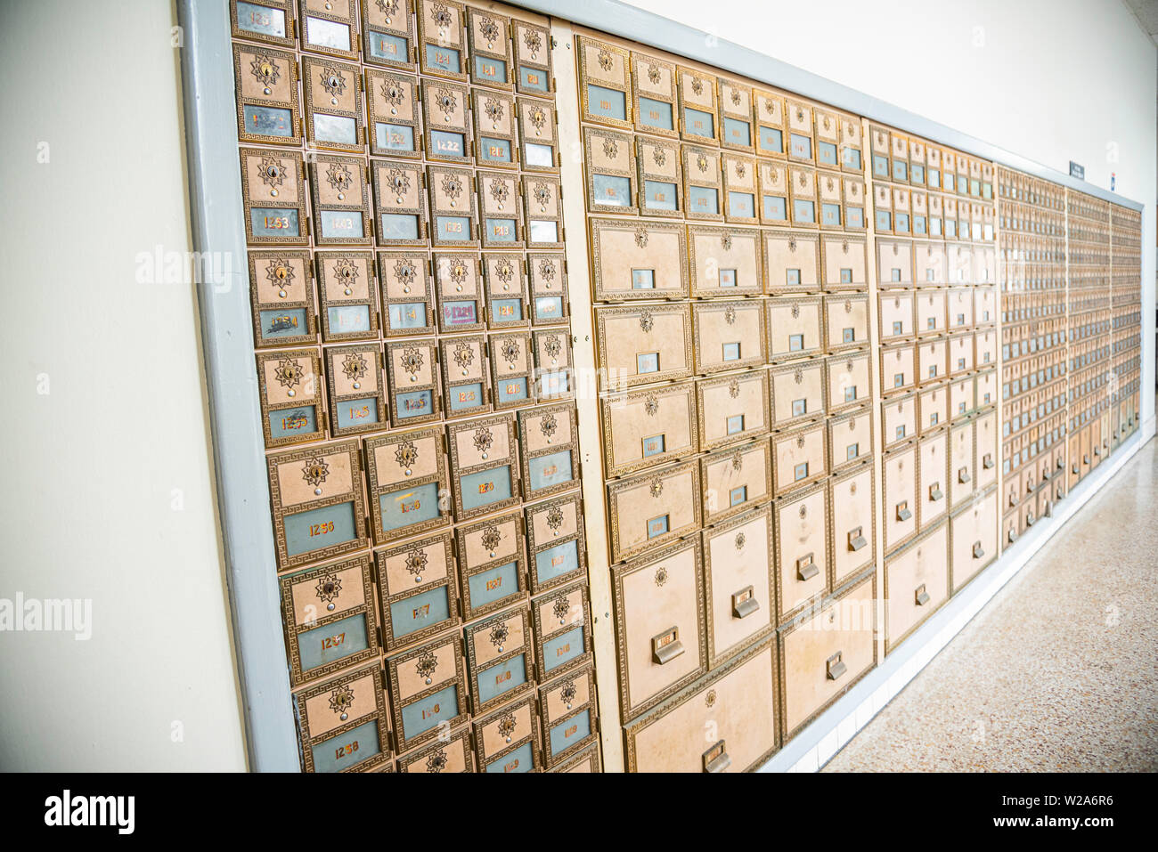 Rows of midcentury modern design post office mailboxes in brass metal