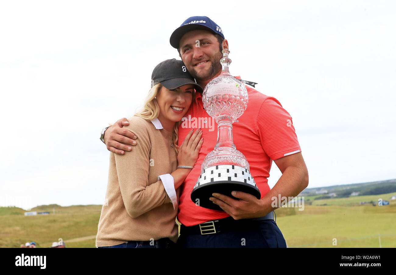 Spain's Jon Rahm with The Irish Open trophy and his fiance Kelley Cahill during day four of the 2019 Dubai Duty Free Irish Open at Lahinch Golf Club. Stock Photo