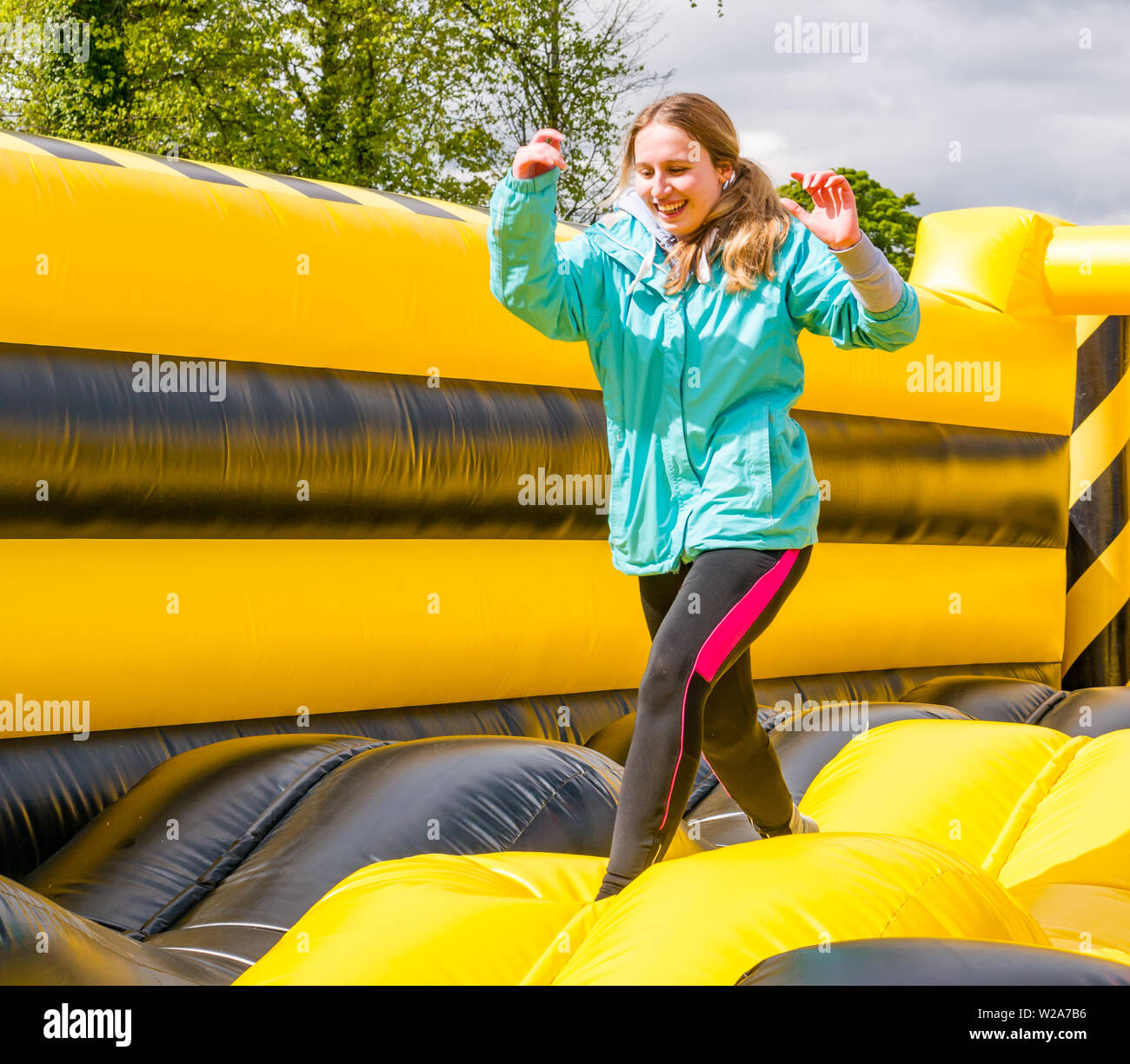 Labyrinth Challenge, Dalkeith Country Park, Midlothian, Scotland, UK.  Woman running in world's longest inflatable obstacle course is over 1000ft in length Stock Photo