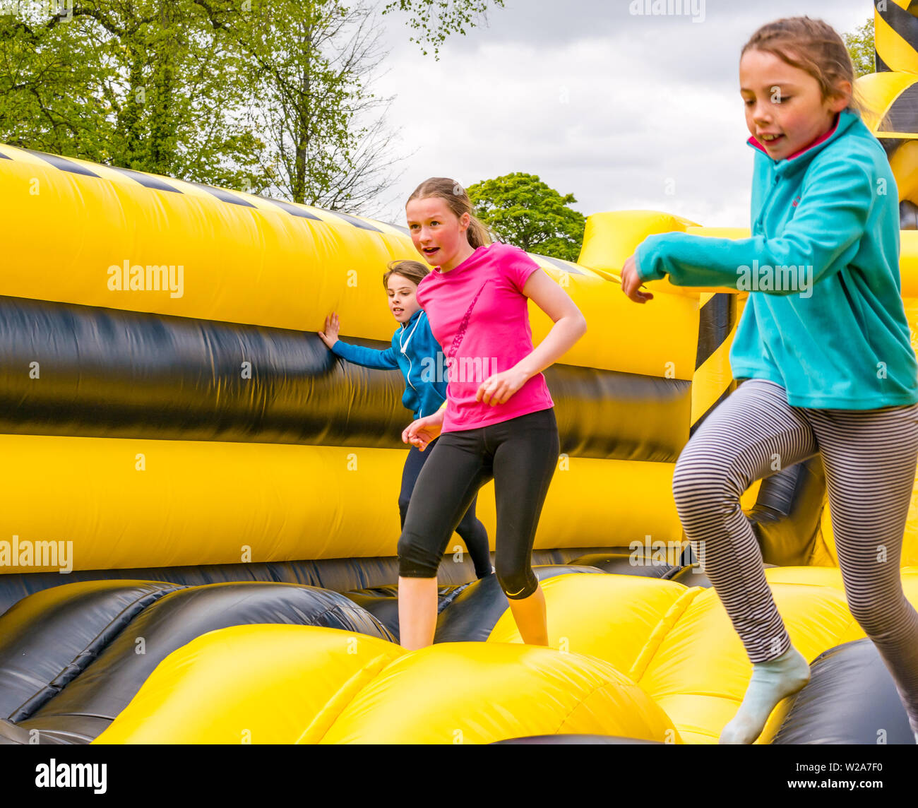 Labyrinth Challenge, Dalkeith Country Park, Midlothian, Scotland, UK.  Girls running in world's longest inflatable obstacle course is over 1000ft in length Stock Photo