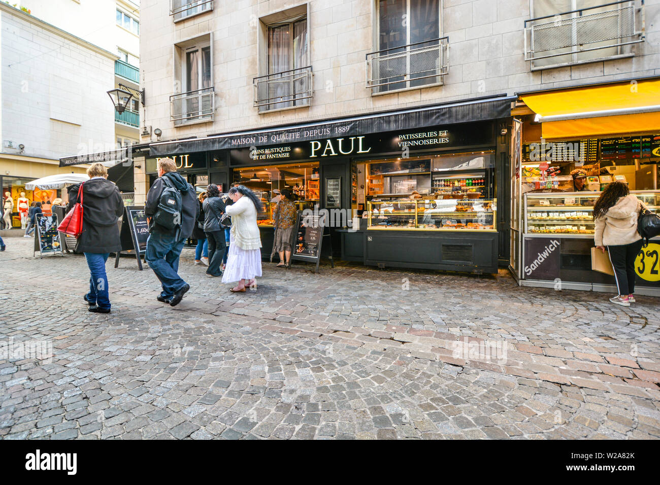 Tourists and local French order at the street outside a historic patisserie bakery in the Normandy city of Rouen, France. Stock Photo