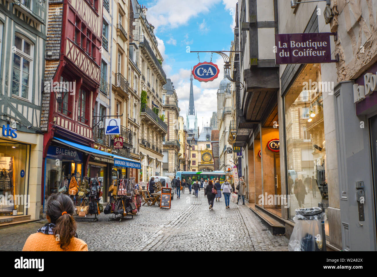 Tourists and locals stroll the Rue du Gros Horloge with the famous astronomical clock in the background in Rouen France Stock Photo