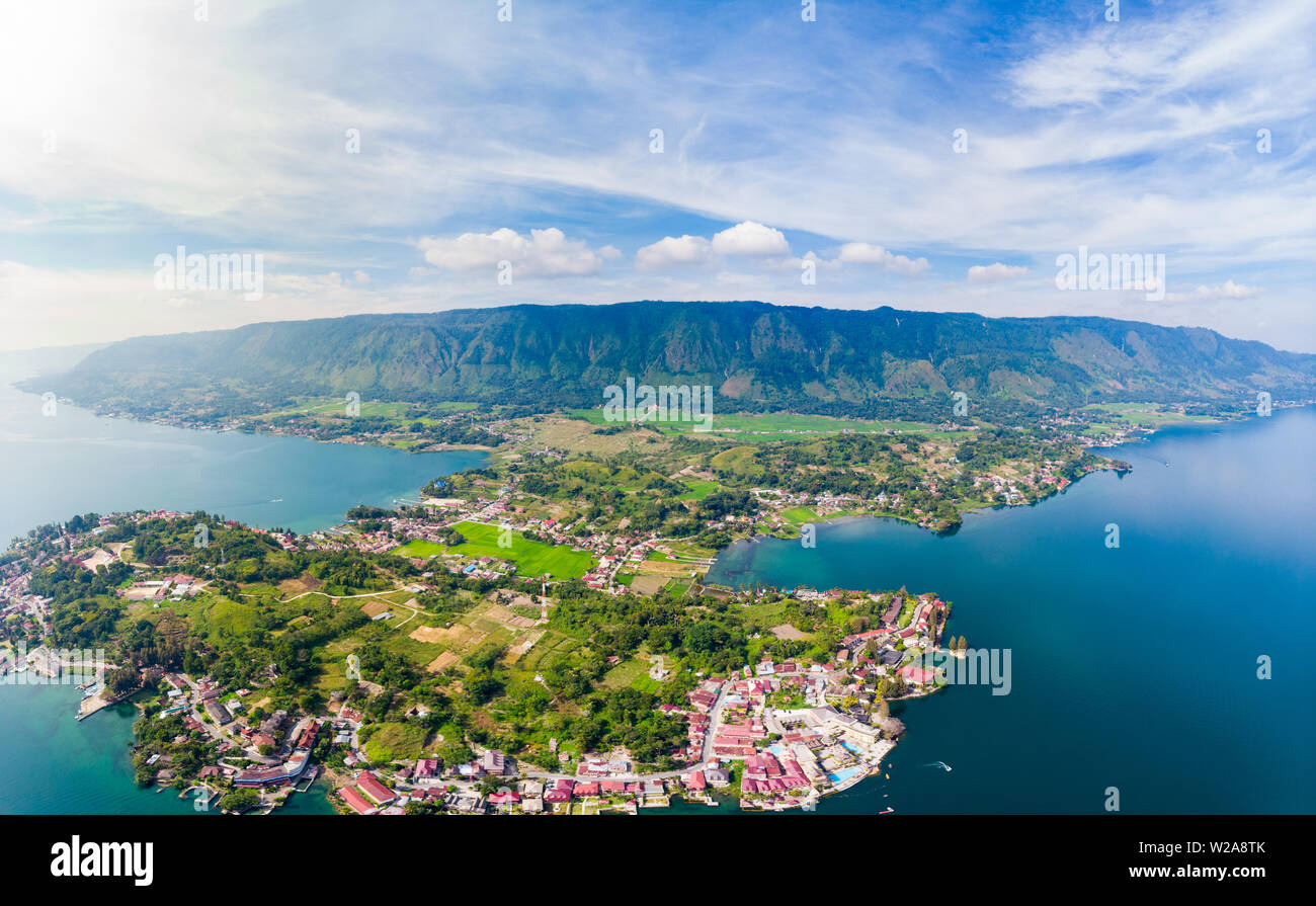 Aerial: lake Toba and Samosir Island view from above Sumatra Indonesia. Huge volcanic caldera covered by water, traditional Batak villages, green rice Stock Photo