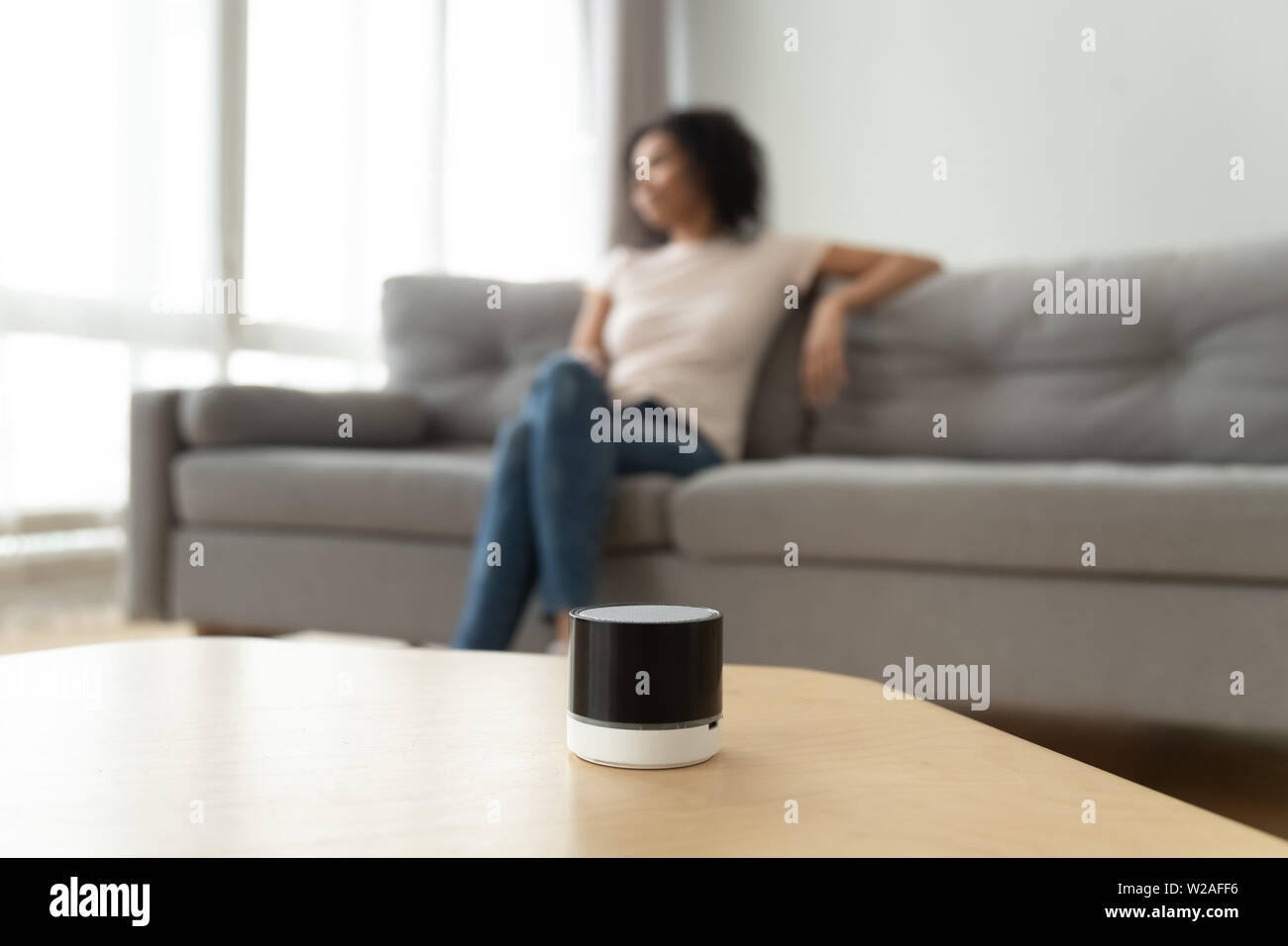 Portable wireless speaker on table with african woman on background Stock Photo