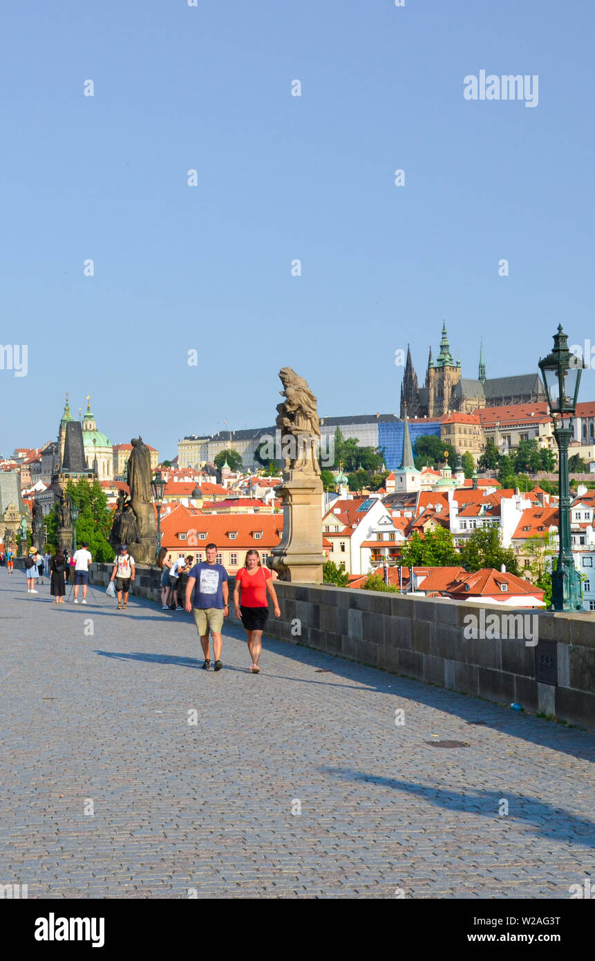 Prague, Czech Republic - June 27th 2019: Tourists on beautiful Charles Bridge in the center of Czech capital. Prague Castle in background. Famous tour Stock Photo