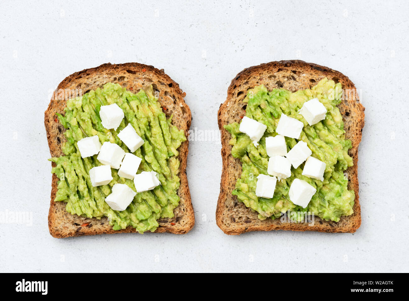 Toast with avocado and feta cheese isolated table top view Stock Photo