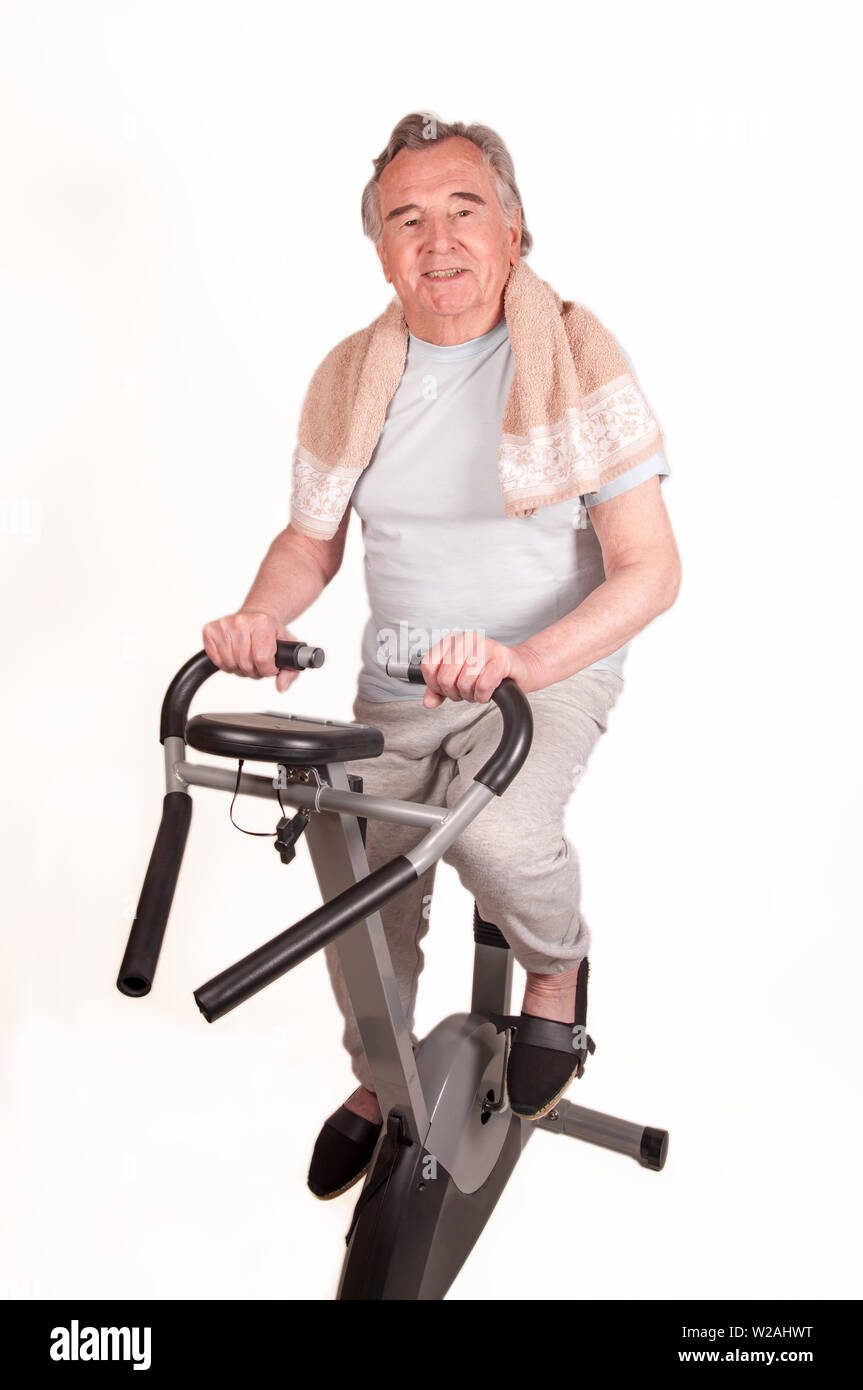 Happy Senior with exercise bike isolated on white Stock Photo