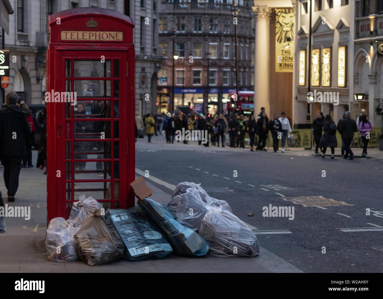 Rubbish bags on London streets next to red phone box Stock Photo
