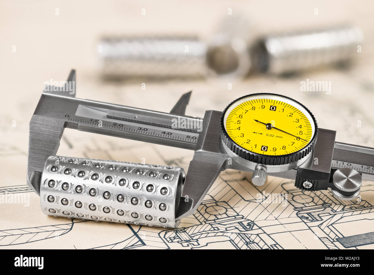 Caliper detail. Linear ball bearings and measuring tool. Technical document. Analog gauge. Round yellow dial and vernier scale. Plan, education study. Stock Photo