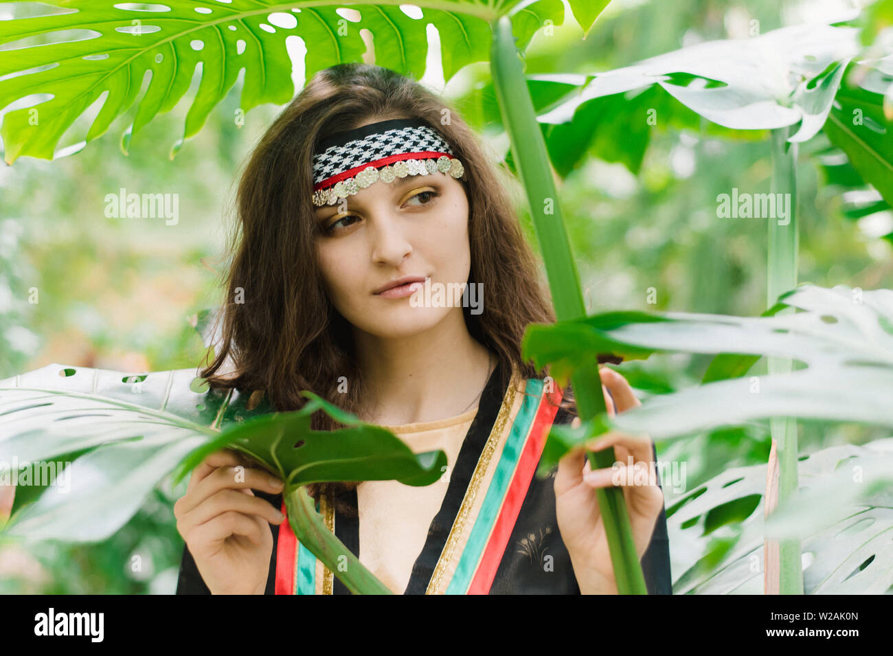 The girl from Jordan on the background of plants and palm leaves ...