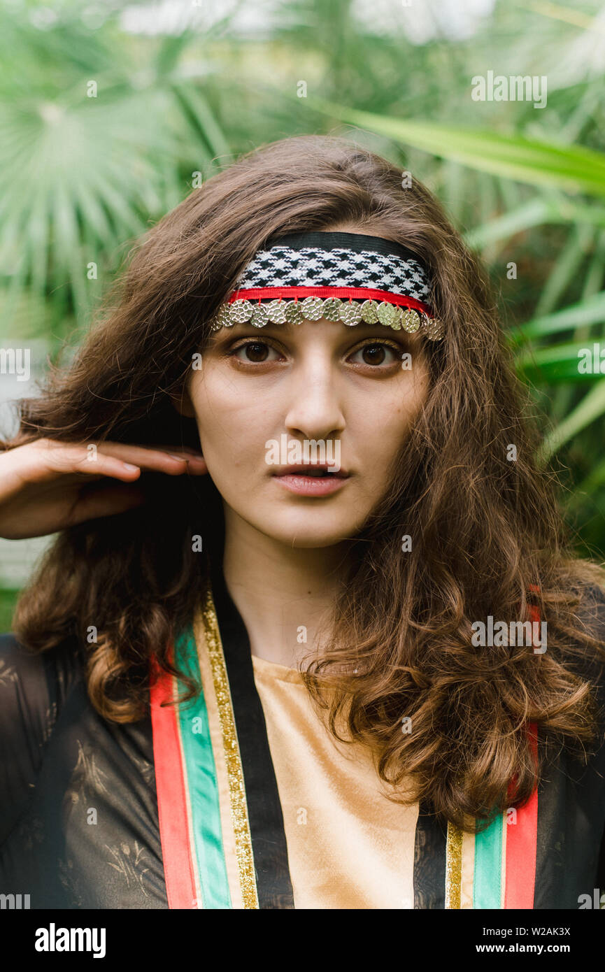 The girl from Jordan on the background of plants and palm leaves ...
