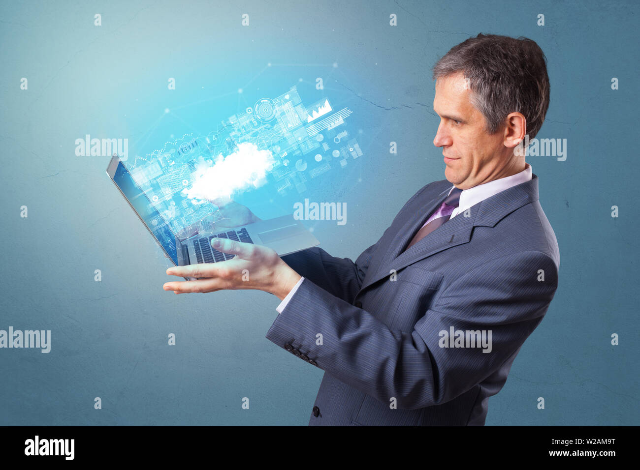 Man holding laptop projecting notifications, symbols and information based on cloud technology system Stock Photo
