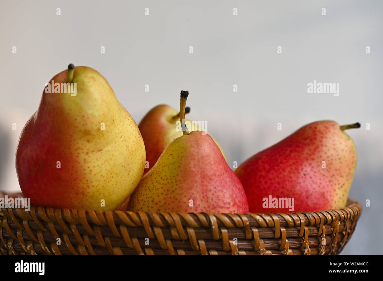 Close up of red and yellow pears in basket Stock Photo