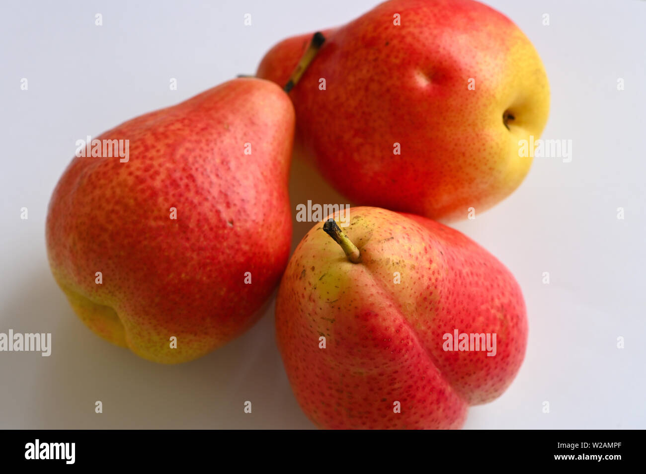 Close up of red and yellow pears on white plate Stock Photo