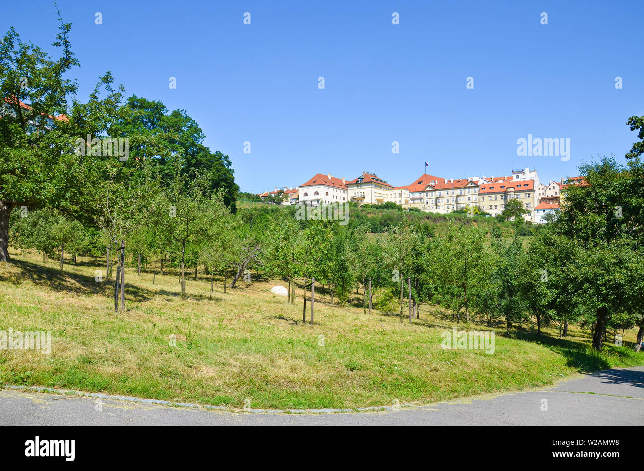 Beautiful green gardens on Petrin Hill in Prague, Czech Republic. Historical buildings in background. Taken on sunny day, blue sky. Popular tourist spot offering view over beautiful city. Czechia. Stock Photo