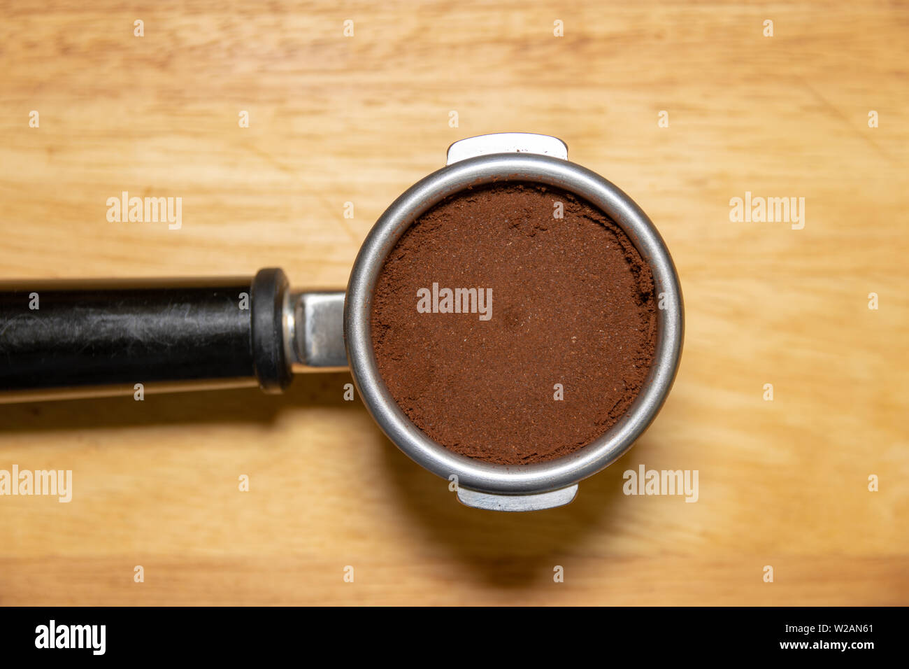 Portafilter on table filled with ground coffee Stock Photo